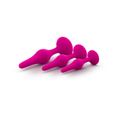 Set of three graduated pink silicone beginner plugs with tapered tips and flared bases on white background.