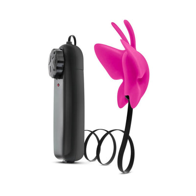 Pink butterfly-shaped clitoral vibrator with black wired remote control and adjustable dial on white background.