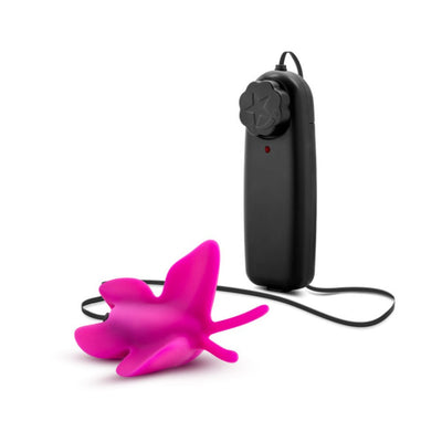 Pink butterfly-shaped clitoral vibrator with black wired remote control on white background.