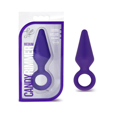 Purple medium-sized silicone anal plug with ring base next to its clear and purple packaging labeled Candy Rimmer Medium.