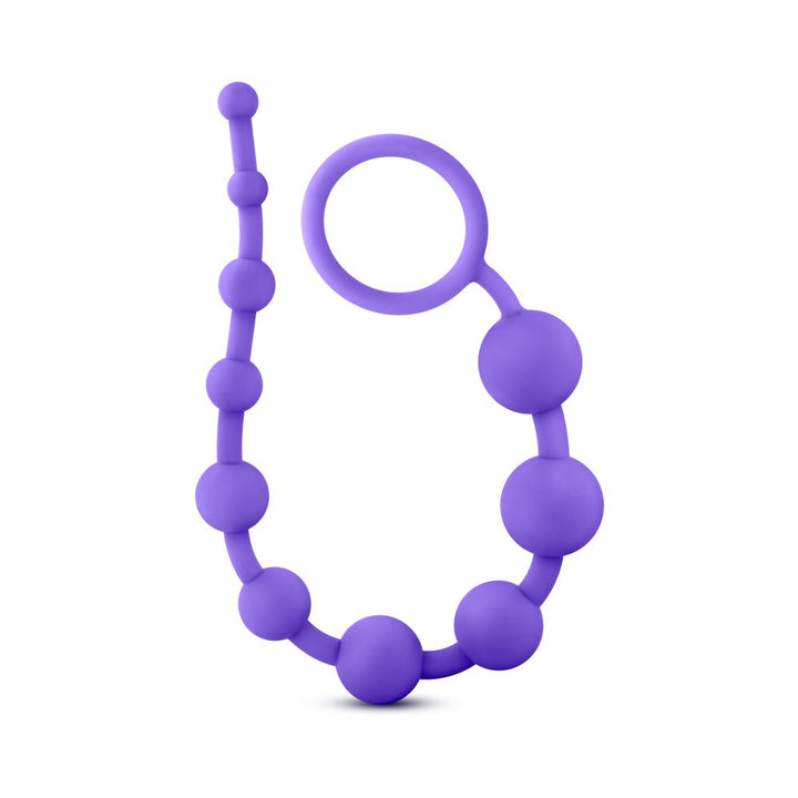 Purple silicone anal beads with graduated sizes and a loop handle for easy retrieval.