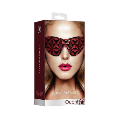 Packaging of a luxury burgundy eye mask with a geometric diamond pattern shown on a model's face.