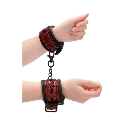 Burgundy luxury hand cuffs with black chain and lobster clasp, featuring a diamond pattern and adjustable fit on wrists.