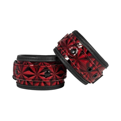 Pair of burgundy and black luxury hand cuffs with a diamond pattern and adjustable straps for a secure fit.