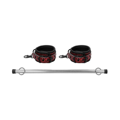 Luxury metal spreader bar with adjustable red and black padded ankle cuffs on a white background.