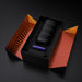 Black textured stroker and purple accessory neatly packaged in a black box with orange striped interior lining.