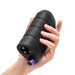 Hand holding a black textured silicone stroker with a purple control button at the base.