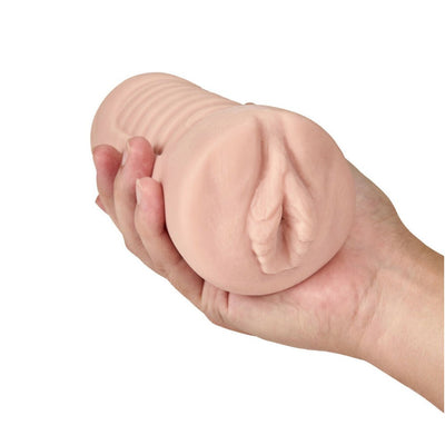 Hand holding a beige, soft textured M Elite Soft And Wet Annabella pleasure sleeve with ribbed exterior.