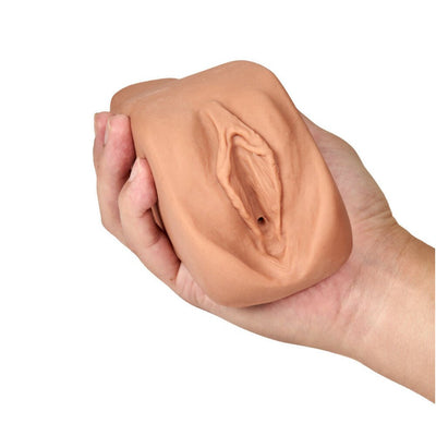 Hand holding a tan-colored soft and textured M Elite Renata pleasure companion sleeve.