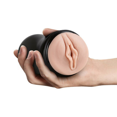 Hand holding a black textured male pleasure cup with a realistic skin-toned orifice detail.
