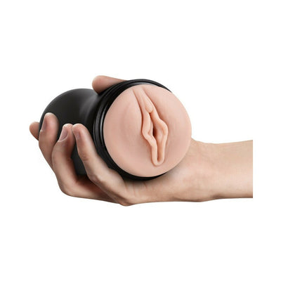 Hand holding a black cylindrical male pleasure device with a realistic skin-toned textured orifice.
