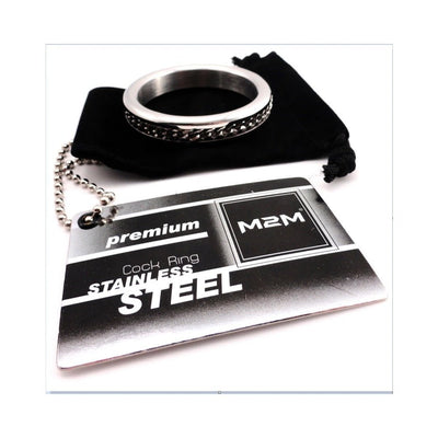 M2M chrome cock ring with chain design resting on black velvet pouch and stainless steel product tag