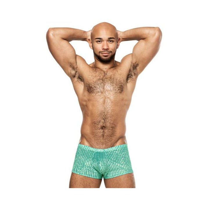 Male model wearing mint green Caribbean Crush mini shorts with a textured striped pattern, posing with hands behind head.