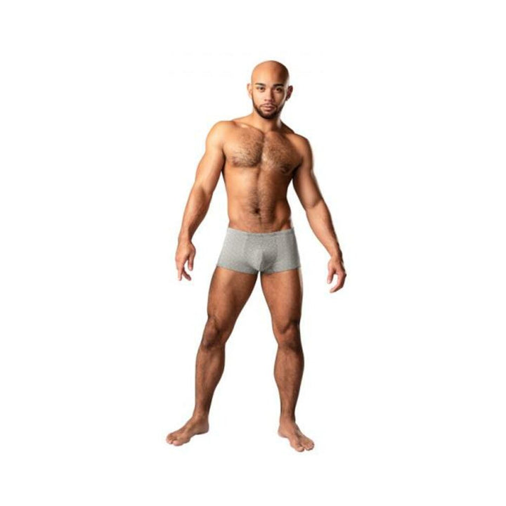 Athletic man wearing grey weave Labyrinth Mini Shorts by Male Power standing against white background.