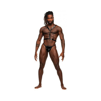 Muscular man wearing Male Power black leather double-ring torso harness and matching thong on white background.