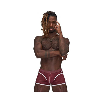 Athletic man wearing burgundy Male Power Sport Mesh mini shorts with white trim and logo waistband on white background.