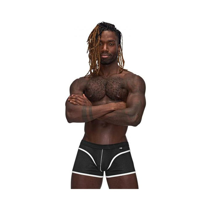 Athletic man wearing black Male Power Sport Mesh Mini Shorts with white trim, standing with arms crossed against white background.
