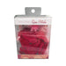 Package of red melting rose petals in a pink mesh bag inside clear display box with white and pink label.