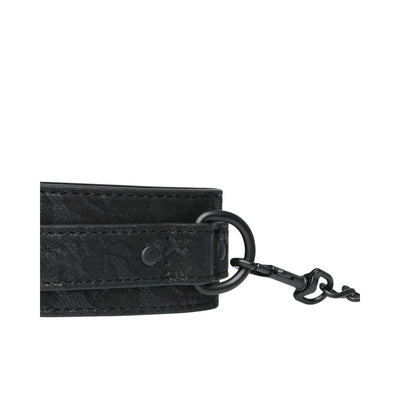Close-up of black lace wrist cuff with metal ring and attached black chain clasp.