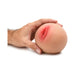 Hand holding a medium-sized realistic silicone breast masturbator with a soft, lifelike texture.