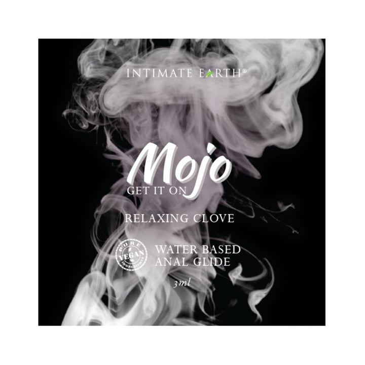 Mojo water-based anal glide 3ml foil packet with relaxing clove, vegan formula on smoky black background.