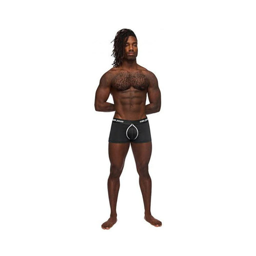 Athletic man wearing black Male Power Helmet shorts with padded pouch and branded waistband standing on white background.