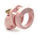 Pink male chastity device with locking mechanism and vented cage design on white background.