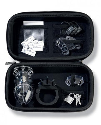 Open black zippered case containing a transparent chastity cage, black adjustable ring, spacers, padlock with keys, and small accessories.