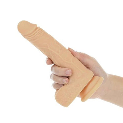 Hand holding a vanilla-colored realistic textured vibrating, rotating, and thrusting dong with suction base.