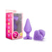 Purple silicone anal plug with heart-shaped base engraved "Do Me Now" next to pink packaging featuring candy heart designs.