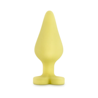 Soft yellow silicone anal plug with heart-shaped base and smooth satin finish for comfortable, secure use.
