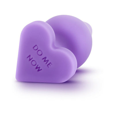 Purple silicone anal plug with heart-shaped base engraved with "DO ME NOW" text, smooth satin finish.