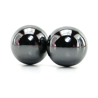 Two smooth, shiny magnetic hematite balls with reflective surfaces on a white background.