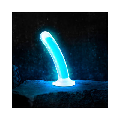 Neo Elite 7-inch neon blue glow-in-the-dark dual-density silicone dildo with suction cup base on dark textured surface.