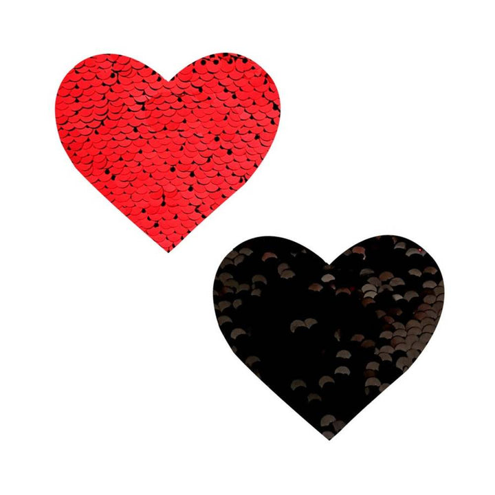 Pair of heart-shaped sequin nipple covers in red and black with reversible shimmer effect.