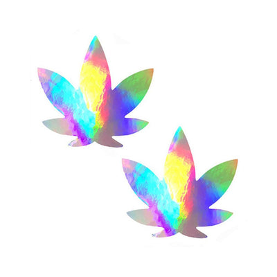 Pair of holographic weed leaf-shaped nipple covers with a rainbow iridescent finish on white background.