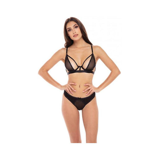 Woman wearing a black sheer 2-piece bra set with strappy details and matching panties on white background