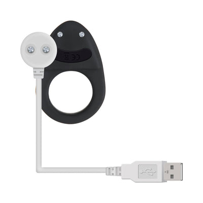 Black silicone vibrating cock ring with USB charging cable on white background.