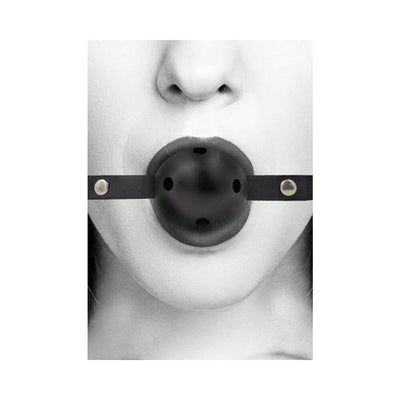 Close-up of a person wearing a black breathable ball gag with bonded leather straps and ventilation holes.