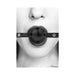 Close-up of a person wearing a black breathable ball gag with bonded leather straps and ventilation holes.