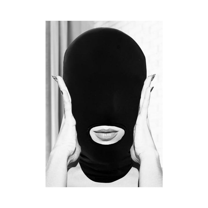 Person wearing a black stretch submission mask with an open mouth hole, hands gently touching the sides of the head.