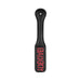 Black leather paddle with red "BAD BOY" text, featuring a stitched handle and a hanging hole at the top.