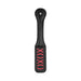 Black leather paddle with stitched handle and reversed red "XOXO" cutout design on the striking paddle face.