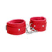 Red plush-lined leather wrist cuffs with adjustable straps and metal chain connector on white background.