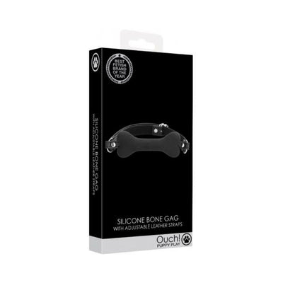 Black silicone bone-shaped gag with adjustable leather straps in Ouch! Puppy Play packaging
