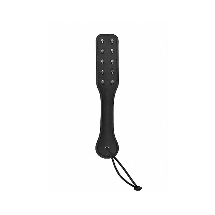 Black faux-leather paddle with embossed skull designs and wrist strap for enhanced grip and impact.