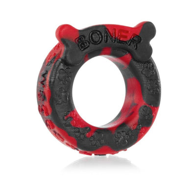 Red and black silicone cockring with bone-shaped tag and embossed paw prints, labeled Boner for puppy play enthusiasts.