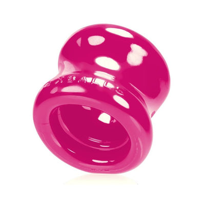 Bright pink flexible ball stretcher with a smooth, rounded design and wide openings on both ends.