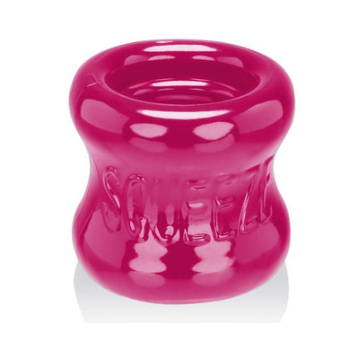 Bright pink flexible ball stretcher with a smooth, rounded shape and embossed "SQUEEZE" branding.