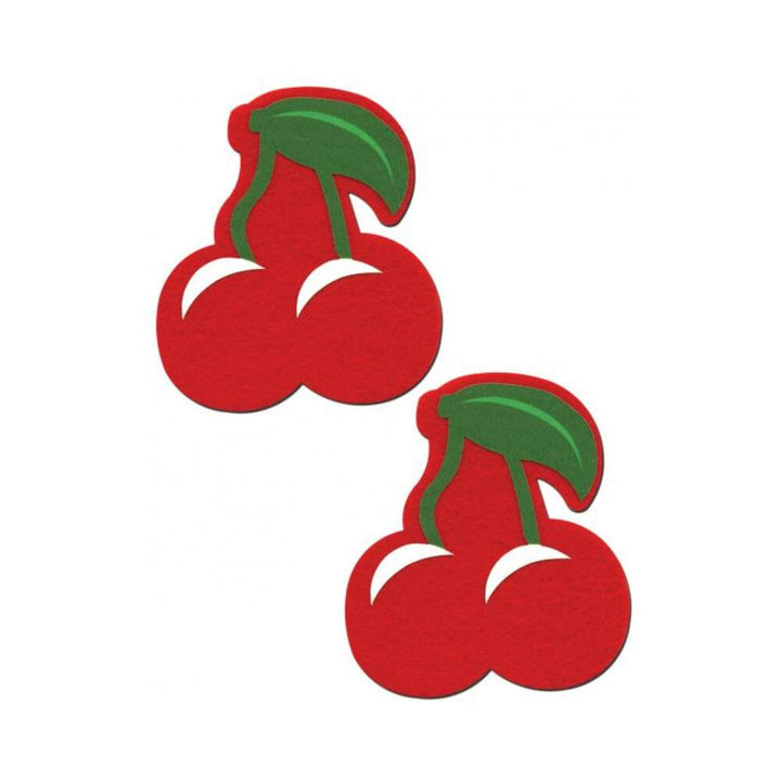 Pair of bright red cherry-shaped nipple pasties with green leaves and stems on a white background.